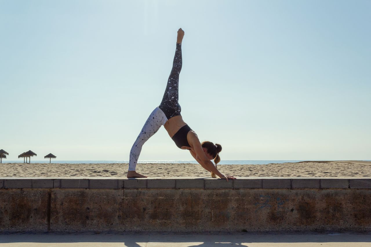 class-04 Woman practicing yoga with an ocean view in the background, showcasing balance and flexibility.